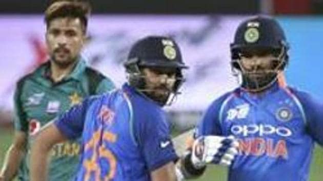 Pakistan's Mohammad Amir, left, looks on as India's Shikhar Dhawan, right, and Rohit Sharma run between the wickets. (AP) Pakistan's Mohammad Amir, left, looks on as India's Shikhar Dhawan, right, and Rohit Sharma run between the wickets. (AP)