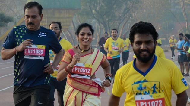 A lady is seen participating in the marathon wearing a traditional Marathi saree.  (Milind Saurkar/HT Photo) 