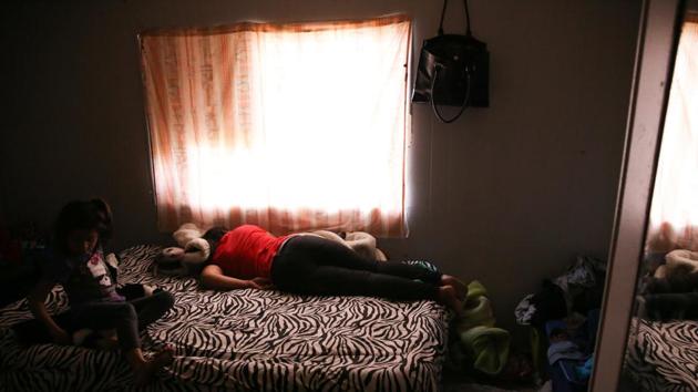 Orfa lies on a bed exhausted as her daughter Rachel sits nearby in the trailer where the family temporarily lived in Texico. After a grueling six-week journey of walking, riding on top of trains, and hitching lifts, in which the family relied largely on the kindness of strangers to eat, they wound up at a shelter in Tijuana. The Mexican border city has become the temporary home for hundreds of caravan migrants, who wait for their turn, sometimes for months, to formally request asylum in the United States. (Loren Elliott / REUTERS)