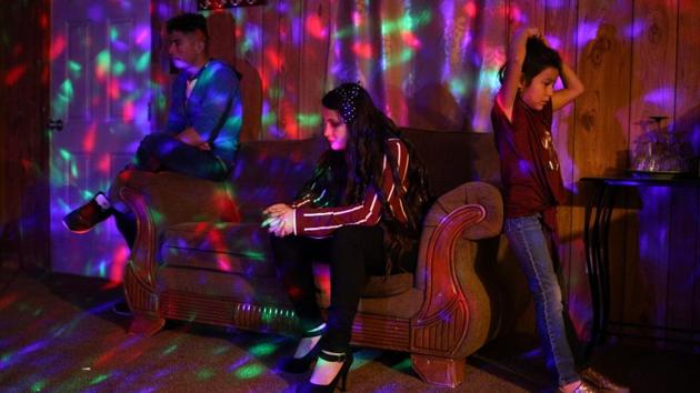 Carolina (C), daughter of Orfa, a migrant from Honduras, sits with friend Jefferson and younger sister Rachel on Christmas Eve inside her family’s trailer in Texico, New Mexico, U.S. Amid gang violence in Honduras, Orfa migrated to the US with her children Carolina, Bayron and Rachel in early 2018. As the fear of uncertainty remains, the family is acclimatising itself to their new lifestyle in the country. (Loren Elliott / REUTERS)