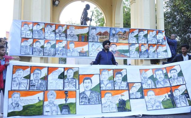Aman Singh Gulati with the portraits of the CRPF personnel killed in J&K.(Deepak Gupta/HT Photo)