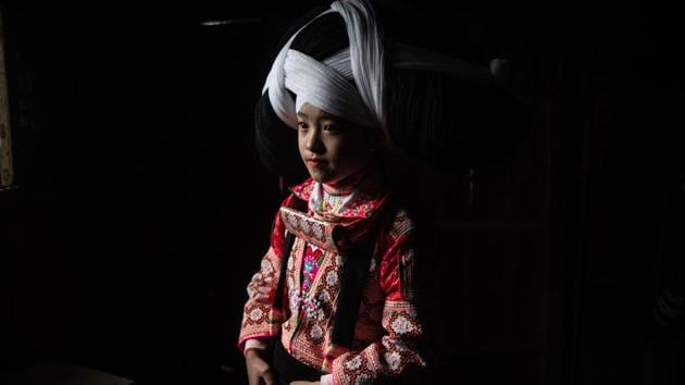 A girl poses for a photo in her wig and traditional costume prior to taking part in the annual flower festival. These headpieces are passed down through generations and worn on a number of occasions to honour their ancestors and preserve their traditions. (Fred Dufour / AFP)