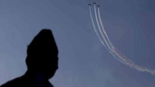 An IAF officer watches the Yakovlevs, a UK based aerobatic team flying Russian-designed aircrafts. (Aijaz Rahi / AP)