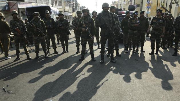 Indian Army soldiers watch a clash between policemen and protestors during curfew in Jammu.(AP Photo)