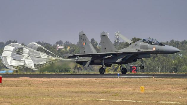 A SU-30 fighter aircraft lands during the inaugural day of the five-day air show. Aero India is a biennial event with flying demonstrations by stunt teams, military and commercial pavilions where aviation companies display their products and technology. (Shailendra Bhojak / PTI)