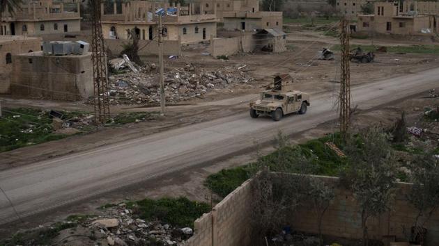 A Humvee drives in a village recently retaken from Islamic State militants by US-backed Syrian Democratic Forces (SDF) near Baghouz, Syria. Islamic State militants are preventing more than 1,000 civilians from leaving a tiny area still held by the extremist group in a village in eastern Syria, a spokesman for the US-backed Syrian militia fighting the group said. (Felipe Dana / AP)