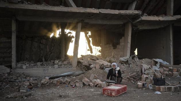 A man selling chicken sits in an area recently retaken by the SDF from Islamic State militants in Hajin, Syria. The tense standoff by the village of Baghouz is the endgame for the militant group that since 2014 controlled a vast stretch of territory across Syria and Iraq — at one point nearly from Aleppo to Baghdad — and ruled for years, aspiring to create an enduring and expanding jihadi state. (Felipe Dana / AP)