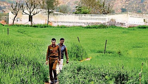 Gurugram police personnel inspect the ancestral land of gangster Sube Singh at Bar Gujjar village, near Manesar police line, on Thursday.(Parveen Kumar/HT Photo)