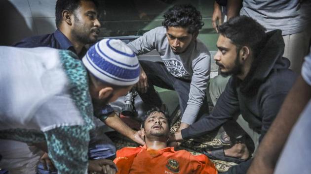 Locals help a Bangladeshi firefighter who lost consciousness while trying to douse flames of the smoldering fire. After a warehouse storing flammable material caught fire in 2010 in Nimtoli, a district near Chawkbazar, killing at least 123 people, authorities promised to bring the area into compliance with building codes, and evict chemical warehouses from buildings where people lived. (AP)