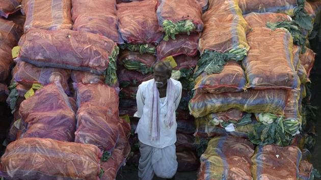 An Indian farmer with his produce waits to negotiate with traders at a wholesale vegetable market in Hyderabad on February 1, 2018. The Indian government is focusing on the agricultural sector in its annual budget, released on February 1. / AFP PHOTO / NOAH SEELAM(AFP)