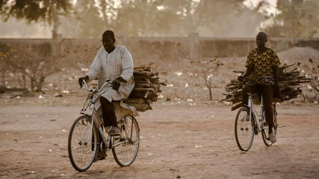 Two men carry firewood in bicycles while on their way home at the camp. From their homes in Adamawa -- Abubakar’s home state -- Malkohi residents say they feel more forgotten than under attack. “Up to now, hospitals have not been provided. Before, [aid groups] gave us drugs, but now we don’t receive any,” said Fanta Ali, a housewife at the camp. (Luis Tato / AFP) 