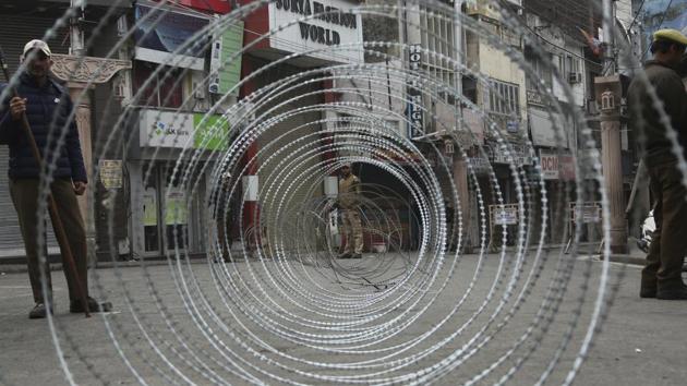 Police men keep vigil next to a barbed wire fencing in Jammu. (AP File Photo) Police men keep vigil next to a barbed wire fencing in Jammu. (AP File Photo)