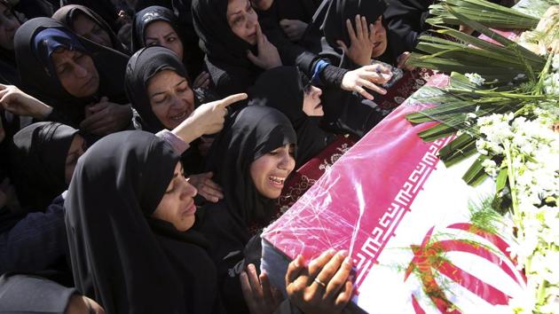 Mourners reach out to touch the caskets of those killed in a suicide car bombing that targeted members of Iran’s powerful Revolutionary Guard in earlier in the week, killing at least 27 people, in Isfahan, Iran. (Ebrahim Noroozi / AP)