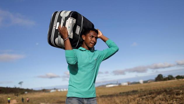 A man carries his suitcase through a field as he tries to cross the border between Venezuela and Brazil in Pacaraima, Roraima state, Brazil. Venezuelans frustrated over their nation’s crippling food and medical shortages are expected to join opposition leaders Saturday in a potentially risky push to deliver international aid that Nicolas Maduro has refused to accept into the country. (Ricardo Moraes / REUTERS)