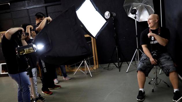 Student with Down syndrome Felippe poses for his mates during a class at the Galera do Click or “Click Crowd” photography school in Sao Paulo, Brazil. The organization Galera do Click provides lessons to young people with Down syndrome, with the intention of providing them with work skills. (Nacho Doce / REUTERS)