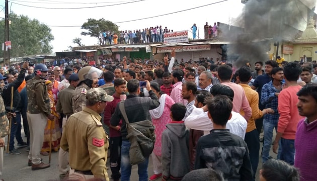 Smoke billows from a property set on fire by protesters in Chitrakoot in Madhya Pradesh after the bodies of two school boys kidnapped on February 12 were found on the banks of the Yamuna river .(HT PHOTO)