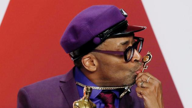 Oscars 2019: Spike Lee kisses his Prince necklace as he poses backstage with his Best Adapted Screenplay award for "BlackKklansman.(REUTERS)