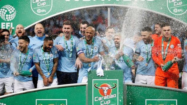 Manchester City's Vincent Kompany and team mates celebrate with the League Cup.(Reuters)