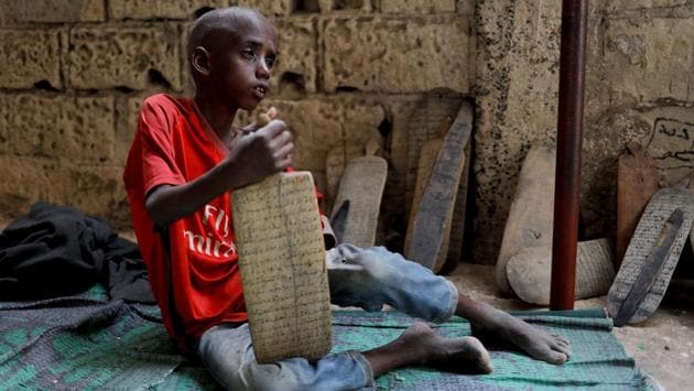 Omar Wone, 8, from Futa and a talibe, sits on the floor of the daara where he lives and learns Quran in Saint-Louis. Many daaras are free from problems of abuse. Success in a daara and strong knowledge of the Quran can lead to a prestigious position as an Imam or a Quranic teacher, known as a marabout. (Zohra Bensemra / REUTERS)