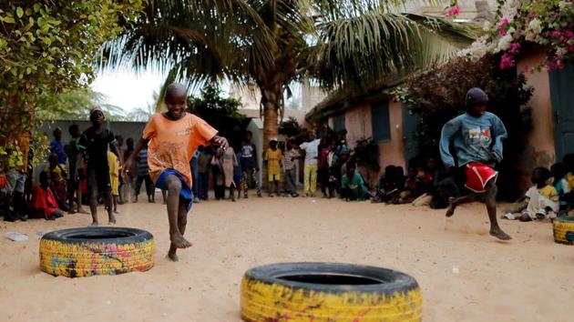 Bassirou Toure, 6, takes part in an entertainment program in the courtyard of Maison de la Gare. Two of the five candidates in the recent presidential election, Ousmane Sonko and Issa Sall, said their programs include measures to regulate the daaras system and end child begging. Human Rights Watch says over 100,000 children are still sent out to beg. (Zohra Bensemra / REUTERS)
