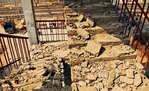 The set of stairs, on either side of the railway tracks, connects to the Daulatabad flyover, and provide a passageway to commuters. The dilapidated condition of the stairs, however, has made them unsafe for use.(Parveen Kumar/HT Photo)