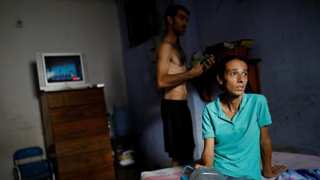 Yaneidi Guzman sits on her mother-in-law’s bed as her husband, Jorge Perez, stands behind her. Guzman’s clothes hang limply off her gaunt frame. The 38-year-old is one of many Venezuelans suffering from malnutrition as the once-prosperous, oil-rich OPEC nation has seen its economy halve in size over the last five years under President Nicolas Maduro. (Carlos Garcia Rawlins / REUTERS) Yaneidi Guzman sits on her mother-in-law’s bed as her husband, Jorge Perez, stands behind her. Guzman’s clothes hang limply off her gaunt frame. The 38-year-old is one of many Venezuelans suffering from malnutrition as the once-prosperous, oil-rich OPEC nation has seen its economy halve in size over the last five years under President Nicolas Maduro. (Carlos Garcia Rawlins / REUTERS)