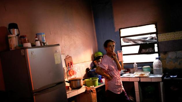 Yaneidi Guzman stands in her kitchen at home in Caracas. On the wall of Guzman’s home in the hillside district of Petare in the capital Caracas, hangs a wooden plaque with the psalm “The Lord is my shepherd, I lack nothing.” Yet her fridge is empty except for a few bags of beans. (Carlos Garcia Rawlins / REUTERS) Yaneidi Guzman stands in her kitchen at home in Caracas. On the wall of Guzman’s home in the hillside district of Petare in the capital Caracas, hangs a wooden plaque with the psalm “The Lord is my shepherd, I lack nothing.” Yet her fridge is empty except for a few bags of beans. (Carlos Garcia Rawlins / REUTERS)