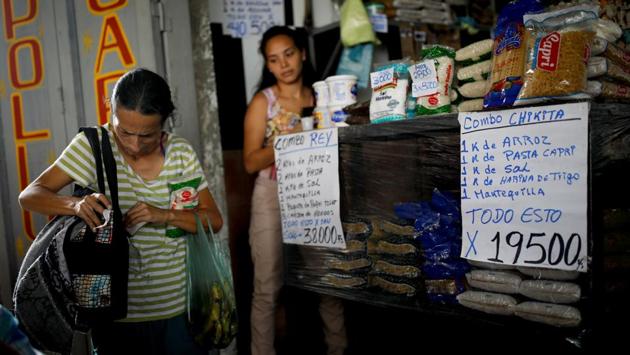 Yaneidi Guzman shops for groceries. A sign (R) advertises a combo offer of a kilo of rice, pasta, salt, flour respectively and a half kilo of butter for 19500 Bolivars. The minimum monthly wage in Venezuela is 18000 Bolivars. Some political analysts said Saturday’s showdown was more about testing the military’s loyalty towards Maduro, rather than aid. (Carlos Garcia Rawlins / REUTERS) Yaneidi Guzman shops for groceries. A sign (R) advertises a combo offer of a kilo of rice, pasta, salt, flour respectively and a half kilo of butter for 19500 Bolivars. The minimum monthly wage in Venezuela is 18000 Bolivars. Some political analysts said Saturday’s showdown was more about testing the military’s loyalty towards Maduro, rather than aid. (Carlos Garcia Rawlins / REUTERS)