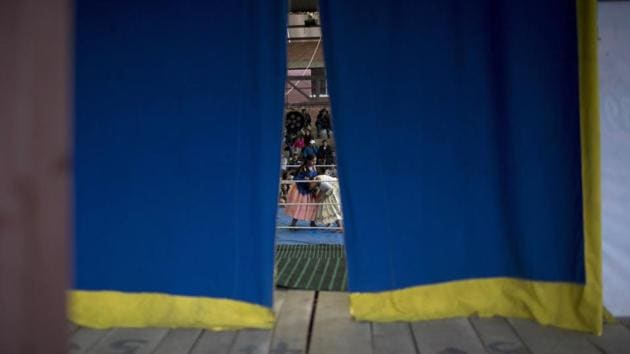 Seen from behind the backstage curtain, young cholita wrestler Dona Chevas, (L), fights with fellow trainee Lucero in El Alto, Bolivia. The sport — known by the English-derived name catchascan — has delighted foreign tourists and photographers for years while building a sense of pride among indigenous women. (Juan Karita / AP) Seen from behind the backstage curtain, young cholita wrestler Dona Chevas, (L), fights with fellow trainee Lucero in El Alto, Bolivia. The sport — known by the English-derived name catchascan — has delighted foreign tourists and photographers for years while building a sense of pride among indigenous women. (Juan Karita / AP)