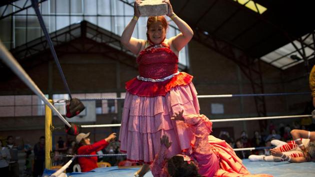 Veteran cholita Jennifer dos Caras, 45, holds a cement block over teen wrestler Lucero la Bonita. “The girls who want to do this sport have to have guts, will, because this is a sport that demands a lot of discipline,” Torrez said. About 50 young women are training at three schools to take up the sport, some at an institution known as Independent Wrestlers of Enormous Risk. (Juan Karita / AP) Veteran cholita Jennifer dos Caras, 45, holds a cement block over teen wrestler Lucero la Bonita. “The girls who want to do this sport have to have guts, will, because this is a sport that demands a lot of discipline,” Torrez said. About 50 young women are training at three schools to take up the sport, some at an institution known as Independent Wrestlers of Enormous Risk. (Juan Karita / AP)