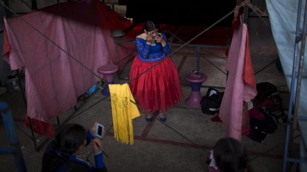 Young cholita wrestler Wara puts her makeup on before competing in the ring. As a match is about to start, the contenders peer into a mirror, apply makeup and perfume and then enter the ring dancing to folkloric music. This time it’s Pepita taking on her teacher. And of course it doesn’t start well. (Juan Karita / AP) Young cholita wrestler Wara puts her makeup on before competing in the ring. As a match is about to start, the contenders peer into a mirror, apply makeup and perfume and then enter the ring dancing to folkloric music. This time it’s Pepita taking on her teacher. And of course it doesn’t start well. (Juan Karita / AP)