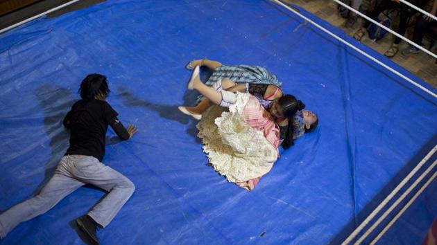 Cholita wrestler Natalia Pepita is pinned down by fellow fighter in training, Wara in the ring. Tatiana Monasterios of the city’s tourist department said the shows “also assert the role of the Ayamara woman, showing her as enterprising, that she, too, can take part in a risky sport.” (Juan Karita / AP) Cholita wrestler Natalia Pepita is pinned down by fellow fighter in training, Wara in the ring. Tatiana Monasterios of the city’s tourist department said the shows “also assert the role of the Ayamara woman, showing her as enterprising, that she, too, can take part in a risky sport.” (Juan Karita / AP)