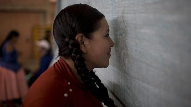 Cholita wrestler Natalia Pepita, 19, watches through a hole in the curtain backstage. Pankarita and the other trainees are still a year away from their full professional debuts. “It’s hard to wrestle,” said Noelia Gonzalez — aka Natalia Pepita. “You need a lot of bravery, strength and training to make a good fight. We fall and we hurt, but that doesn’t matter because the public has fun.” (Juan Karita / AP) Cholita wrestler Natalia Pepita, 19, watches through a hole in the curtain backstage. Pankarita and the other trainees are still a year away from their full professional debuts. “It’s hard to wrestle,” said Noelia Gonzalez — aka Natalia Pepita. “You need a lot of bravery, strength and training to make a good fight. We fall and we hurt, but that doesn’t matter because the public has fun.” (Juan Karita / AP)