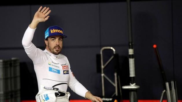 McLaren driver Fernando Alonso waves to spectators in the pit during the qualifying session at the Yas Marina racetrack in Abu Dhabi.(REUTERS)