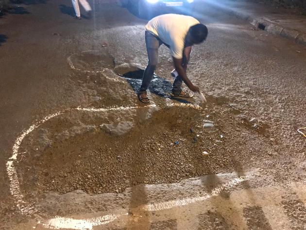 One of the protesting residents mark a pothole using paint, which was dedicated to Cidco officials.(HT Photo)