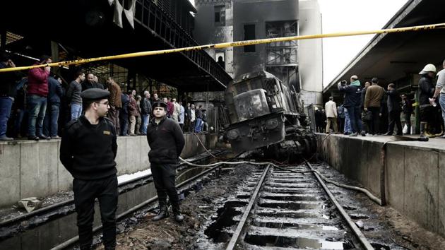 Policemen stand guard in front of a damaged train inside Ramses train station in Cairo, Egypt after at least 20 people were killed and dozens injured when a railcar rammed into a barrier inside the station causing an explosion of the fuel tank and triggering a huge blaze. (Nariman El-Mofty / AP) Policemen stand guard in front of a damaged train inside Ramses train station in Cairo, Egypt after at least 20 people were killed and dozens injured when a railcar rammed into a barrier inside the station causing an explosion of the fuel tank and triggering a huge blaze. (Nariman El-Mofty / AP)