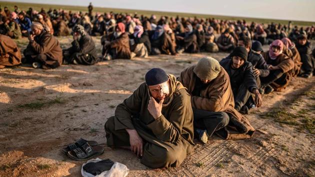 Men suspected of being Islamic State (IS) fighters wait to be searched by members of the Kurdish-led Syrian Democratic Forces (SDF) after leaving the IS group’s last holdout of Baghouz, Syria. (Bulent Kilic / AFP) Men suspected of being Islamic State (IS) fighters wait to be searched by members of the Kurdish-led Syrian Democratic Forces (SDF) after leaving the IS group’s last holdout of Baghouz, Syria. (Bulent Kilic / AFP)