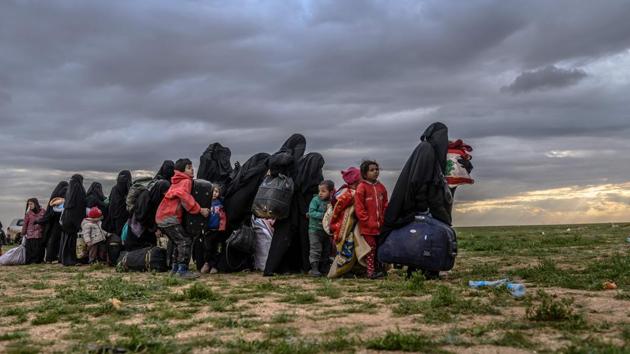 Women and children wait to be searched by members of the Kurdish-led Syrian Democratic Forces (SDF) after leaving the Islamic State (IS) group’s last holdout of Baghouz, in Syria’s northern Deir Ezzor province. (Bulent Kilic / AFP) Women and children wait to be searched by members of the Kurdish-led Syrian Democratic Forces (SDF) after leaving the Islamic State (IS) group’s last holdout of Baghouz, in Syria’s northern Deir Ezzor province. (Bulent Kilic / AFP)