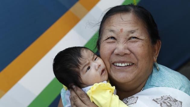 A woman holds her granddaughter as they watch aircraft perform aerobatic maneuvers on the last day of ‘Aero India 2019’, at Yelahanka air base in Bengaluru, Karnataka. (Aijaz Rahi / AP) 