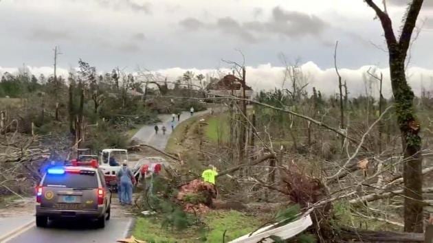 People clear fallen trees and debris on a road following a tornado in Beauregard, Alabama, U.S.(Reuters)