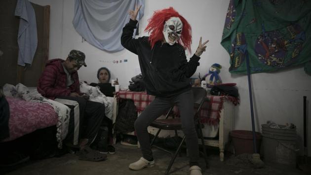 Josue Mejia Lucero (L), and Milagro de Jesus Henriquez Ayala, relax on their bed as Milagro’s sister Xiomara jokes around in a clown mask. With Milagro nearly six months pregnant, the girls are too afraid to cross the border wall topped with concertina wire. (Emilio Espejel / AP) Josue Mejia Lucero (L), and Milagro de Jesus Henriquez Ayala, relax on their bed as Milagro’s sister Xiomara jokes around in a clown mask. With Milagro nearly six months pregnant, the girls are too afraid to cross the border wall topped with concertina wire. (Emilio Espejel / AP)