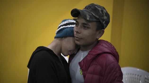Milagro de Jesus Henriquez Ayala, 15, and Josue Mejia Lucero, 17, embrace at the end of a Christian religious service in the Agape World Mission shelter in Tijuana, Mexico. The 15-year-old Salvadoran girl is staying at a shelter in Tijuana with her 13-year-old sister, Xiomara — part of an untold number of Central American youths who travelled with a migrant caravan that crossed Mexico and landed here in November. (Emilio Espejel / AP) Milagro de Jesus Henriquez Ayala, 15, and Josue Mejia Lucero, 17, embrace at the end of a Christian religious service in the Agape World Mission shelter in Tijuana, Mexico. The 15-year-old Salvadoran girl is staying at a shelter in Tijuana with her 13-year-old sister, Xiomara — part of an untold number of Central American youths who travelled with a migrant caravan that crossed Mexico and landed here in November. (Emilio Espejel / AP)