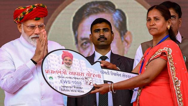 Prime Minister Narendra Modi hands over the key of a house to a beneficiary of the Pradhan Mantri Awas Yojana, in Jamnagar, Gujarat, Monday.(PTI)