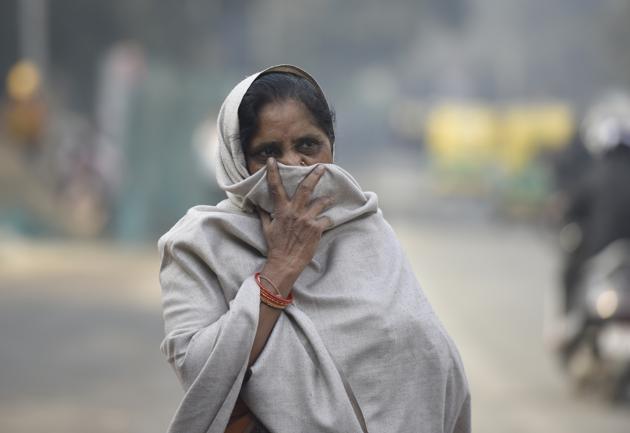 A woman covers her face to protect herself from air pollution near Pragati Maidan in New Delhi.(HT file/Biplov Bhuyan)