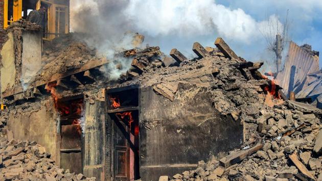 Smoke rises from a house destroyed during a gunbattle between security forces and militants at Reshi Mohlala area of Tral in Pulwama district of south Kashmir, Tuesday.(PTI)