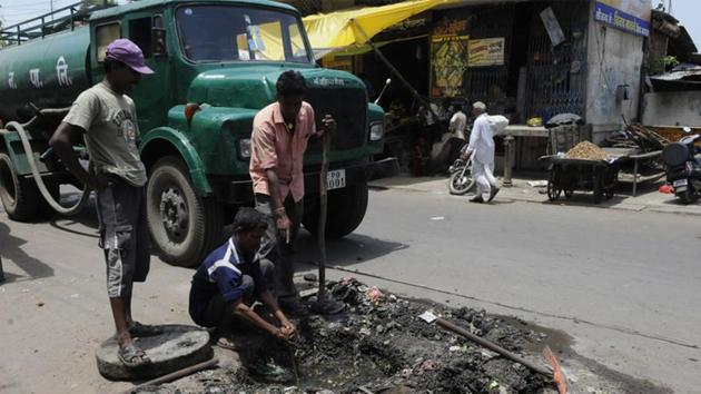 Sanitary workers clear a choked drain, Indore (HT File photo) Sanitary workers clear a choked drain, Indore (HT File photo)