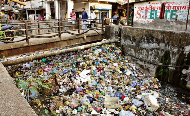 Slum dwellers near Nulpada in Thane dump garbage into the nearby nullah.(Praful Gangurde/ HT)