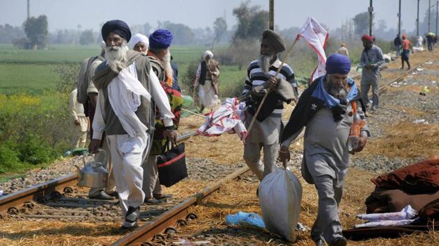 Farmers carry their belongings as they prepare to move back to their native villages from the Delhi-Amritsar railway tracks after calling off their strike, at village Devi Dass Pura, about 20kms from Amritsar, on Wednesday.(PTI)
