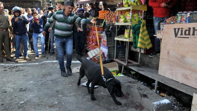 A sniffer dog and police officer inspect the site of a grenade blast at the Jammu bus stand on Thursday. (Nitin Kanotra / Hindustan Times) A sniffer dog and police officer inspect the site of a grenade blast at the Jammu bus stand on Thursday. (Nitin Kanotra / Hindustan Times)