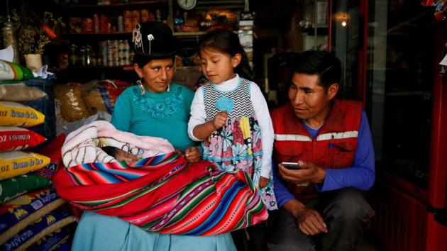 Ana Huanca, her six-week-old baby Luciana, her elder daughter Anabel, 5, and husband Luis, at their food shop in La Paz, Bolivia. In Bolivia, mothers are entitled to 15 days of maternity leave before they give birth and 45 days after they’ve given birth. However Ana and Luis are among the majority of Bolivian workers who have no regular jobs which would entitle them to benefits like maternity leave. (David Mercado / REUTERS) Ana Huanca, her six-week-old baby Luciana, her elder daughter Anabel, 5, and husband Luis, at their food shop in La Paz, Bolivia. In Bolivia, mothers are entitled to 15 days of maternity leave before they give birth and 45 days after they’ve given birth. However Ana and Luis are among the majority of Bolivian workers who have no regular jobs which would entitle them to benefits like maternity leave. (David Mercado / REUTERS)